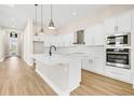 Modern kitchen with white cabinets, quartz countertops, and island at 815 Liliana Dr, Deland, FL 32724