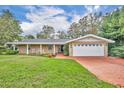 Single story home with brick driveway and rocking chairs on the porch at 279 Rippling Ln, Winter Park, FL 32789