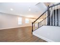 Bright living room with wood-look tile flooring, and a view of the kitchen and staircase at 12737 Brodlove Ln, Winter Garden, FL 34787