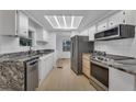 Modern kitchen featuring granite countertops and stainless steel appliances at 411 Palo Verde Dr, Leesburg, FL 34748