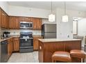 Kitchen with island, stainless steel appliances, and wood cabinets at 12527 Floridays Resort Dr # 312-E, Orlando, FL 32821
