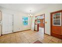 Dining room with tiled floor, wood-paneled walls, and access to kitchen at 3034 Touraine Ave, Orlando, FL 32812