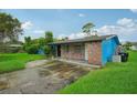 Brick home with blue painted siding, driveway, and grassy yard at 3034 Touraine Ave, Orlando, FL 32812