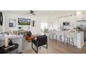 Open concept kitchen features white shaker cabinets, island, and breakfast bar at 1987 Peel Ave, Orlando, FL 32806