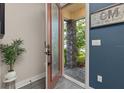 Inviting entryway with an open door, stone accents, and wood flooring at 1409 Bellamy Dr, Reunion, FL 34747