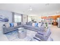 Open-concept living room with sectional sofa, flows into kitchen and dining areas at 4498 Monado Dr, Kissimmee, FL 34746
