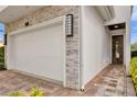 Two-car garage with stone facade and modern door at 837 Desert Mountain Ct, Reunion, FL 34747