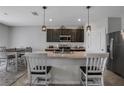 Kitchen with island, dark cabinets, and pendant lighting at 209 Sofia Ln, Lake Alfred, FL 33850