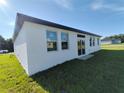 Newly built home with a white exterior, black accents, and a two-car garage at 1300 Hillsborough Ct, Kissimmee, FL 34759