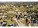 An aerial view showcasing a house in a residential neighborhood near a golf course at 13707 Calle De Ora Ct, Clermont, FL 34711