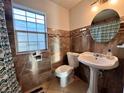 Bathroom with pedestal sink, tiled shower, and decorative accents at 813 S Florida Ave, Deland, FL 32720