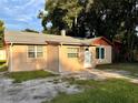 Tan ranch style house with orange accents and a white door at 813 S Florida Ave, Deland, FL 32720