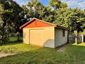 Detached garage with tan block walls and an orange roof at 813 S Florida Ave, Deland, FL 32720