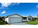White single story home with a two car garage and landscaped lawn at 4901 Pleasant Hollow Trl, Lakeland, FL 33811