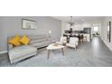 Open concept living and dining area with gray sectional sofa and adjacent kitchen at 875 Ocean Course Ave, Davenport, FL 33896