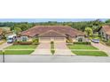 Tan two-story home with double garage and manicured lawn at 26841 Bella Vista Dr, Howey In The Hills, FL 34737