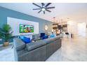 Open living room, kitchen, and dining area with tile floors and modern furnishings at 951 Splash Shot Pl # 0, Davenport, FL 33896