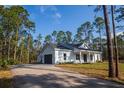 White farmhouse with gray garage door and paved driveway at 6979 Big Bend Dr, St Cloud, FL 34771