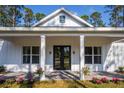Charming front porch with black double doors and white columns at 6979 Big Bend Dr, St Cloud, FL 34771