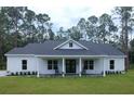 White farmhouse with a covered porch and rocking chairs at 6979 Big Bend Dr, St Cloud, FL 34771
