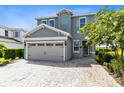 Two-story house with gray siding, shutters, and a paver driveway at 7443 Marker Ave, Kissimmee, FL 34747