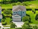 Two-story house with gray siding and a paver driveway, aerial view at 7443 Marker Ave, Kissimmee, FL 34747