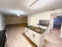 Open concept kitchen with island, granite countertops, and light wood flooring at 366 Fairfield Dr, Sanford, FL 32771