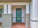 Modern teal front door with glass panels and brick entryway at 8851 Sperry St, Orlando, FL 32827