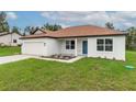 Front view of house, featuring a brown roof and blue door at 11 Spruce Pass, Ocala, FL 34472