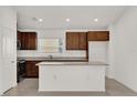 Modern kitchen with island, stainless steel appliances, and dark cabinets at 607 Alder Ln, Auburndale, FL 33823