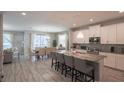 Modern kitchen featuring white cabinets, granite countertops, and a breakfast bar at 4704 Sleepy Hollow Dr, Kissimmee, FL 34746