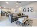 Open concept living room with modern sectional sofa and kitchen views at 7740 Sandy Ridge Dr # 100, Reunion, FL 34747