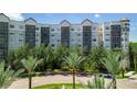 Upscale condo building with palm trees and a gated entrance at 14501 Grove Resort Ave # 3132, Winter Garden, FL 34787