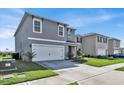 Two-story home with gray siding, a two-car garage, and landscaping at 117 Eagleview Loop, Davenport, FL 33837