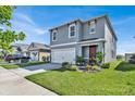 Two-story home with gray siding, a two-car garage, and landscaping at 117 Eagleview Loop, Davenport, FL 33837