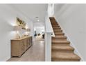 Bright and spacious entryway with a carpeted staircase and console table at 117 Eagleview Loop, Davenport, FL 33837