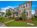 Two-story house with neutral exterior and front yard landscaping at 8217 De Haven Street, Orlando, FL 32832