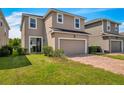 Two-story house with a two-car garage and landscaped lawn at 8217 De Haven Street, Orlando, FL 32832