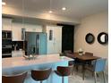 Modern kitchen with island, stainless steel appliances, and dining area at 3141 Paradox Cir # 306, Kissimmee, FL 34746
