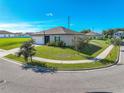 Single-story home with a two-car garage and well-manicured lawn at 16486 Blooming Cherry Dr, Groveland, FL 34736