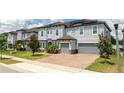 Two-story house with gray siding, solar panels, and two-car garage at 8324 Ludington Cir, Orlando, FL 32836