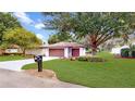 Single-story home with two-car garage and landscaped lawn at 105 Tuxford S Dr, Haines City, FL 33844