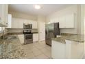 Kitchen boasts granite countertops, stainless steel appliances, and white cabinets at 276 Tavestock Loop, Winter Springs, FL 32708