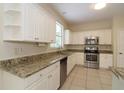 Well-lit kitchen with white cabinets, granite countertops, and stainless steel appliances at 276 Tavestock Loop, Winter Springs, FL 32708