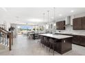 Open concept kitchen with island, stainless steel appliances, and white quartz countertops at 12934 Promise Pl, Orlando, FL 32832