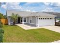 Single-story house with gray siding, a two-car garage, and well-maintained lawn at 4704 Cheyenne Point Trl, Kissimmee, FL 34746