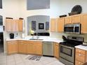 Spacious kitchen featuring stainless steel appliances and light wood cabinets at 320 Henley Cir, Davenport, FL 33896