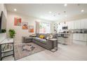 Open concept living room and kitchen with grey sectional sofa and modern kitchen at 7525 Sunflower Cir, Kissimmee, FL 34747