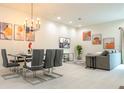 Open concept dining area with glass table and six gray chairs at 7525 Sunflower Cir, Kissimmee, FL 34747