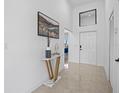Modern entryway with a gold console table, decor, and white door at 6311 Chorus Dr, Mascotte, FL 34753